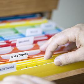 Una persona sosteniendo una carpeta de archivos con un diseño colorido.