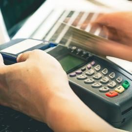 Una persona que realiza una compra en línea utilizando una tarjeta de crédito en una computadora portátil.