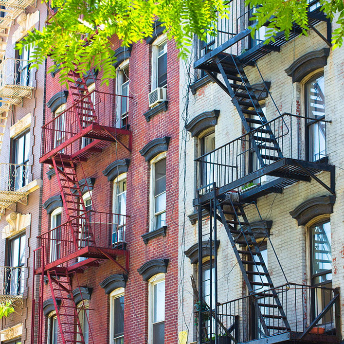 Una hilera de edificios de apartamentos con escaleras de incendios, que proporcionan medidas de seguridad para los residentes.