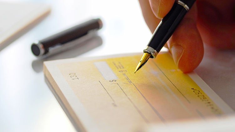 Una guía paso a paso sobre cómo escribir un cheque. Incluye el nombre, la fecha, el importe y la firma del destinatario.